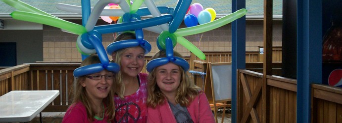 Three girls share a crazy looking balloon hat